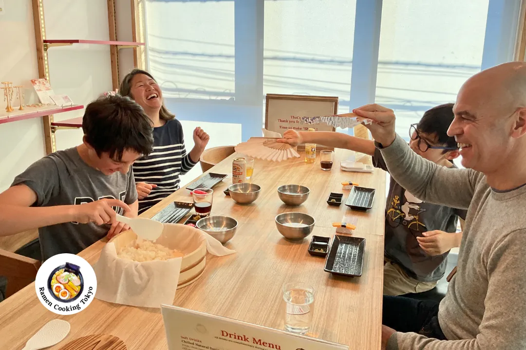 Una famiglia condivide un caldo momento di risate con la chef durante un corso di cucina in piccolo gruppo a Tokyo