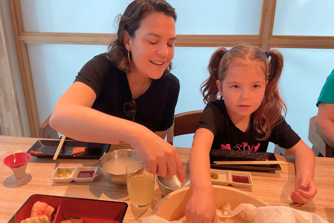 Mother and daughter smiling while preparing sushi rice