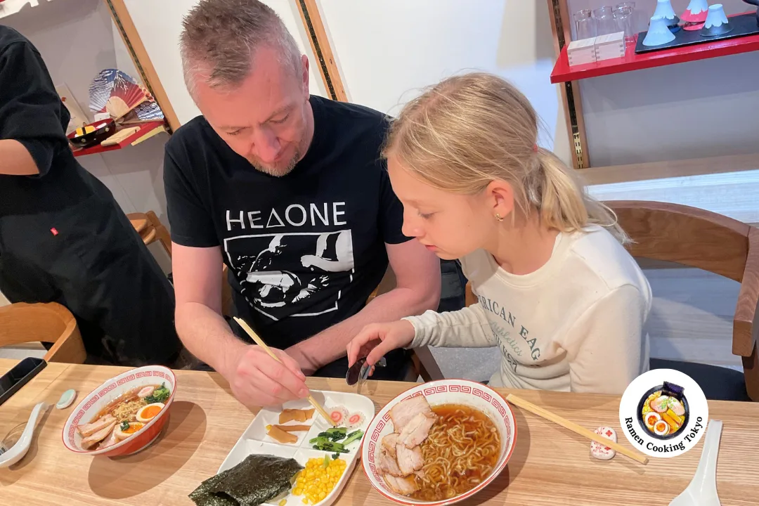 Father and daughter adding toppings to their ramen together