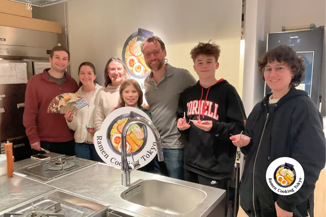 Famiglia con tre bambini festeggia dopo il corso di cucina a Tokyo