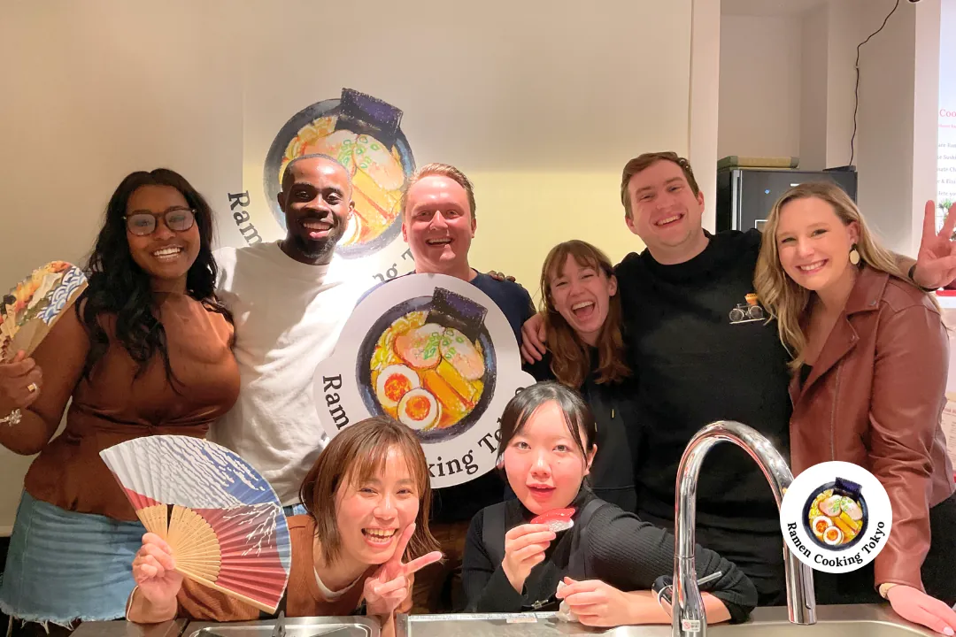 Amici internazionali festeggiano dopo un'esperienza di corso di cucina di ramen a Tokyo