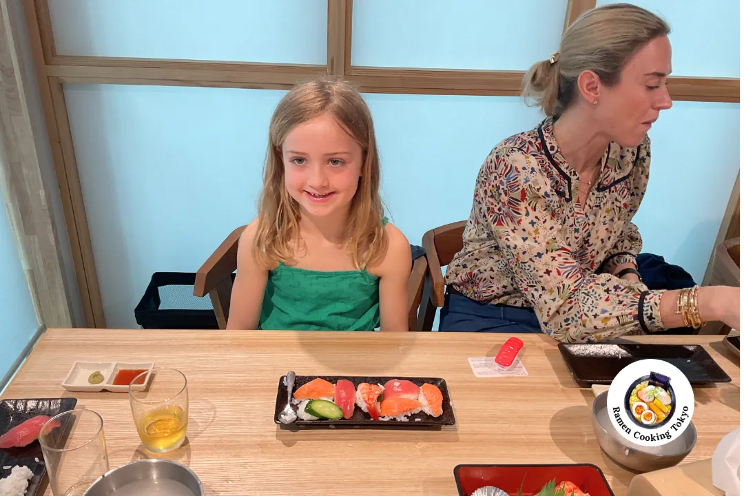 Giovane bambina con sua madre durante un corso di preparazione di sushi a Tokyo