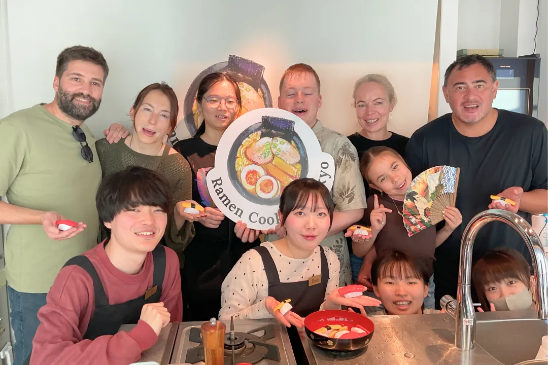 Gruppo internazionale festeggia dopo un corso di cucina di ramen a Tokyo