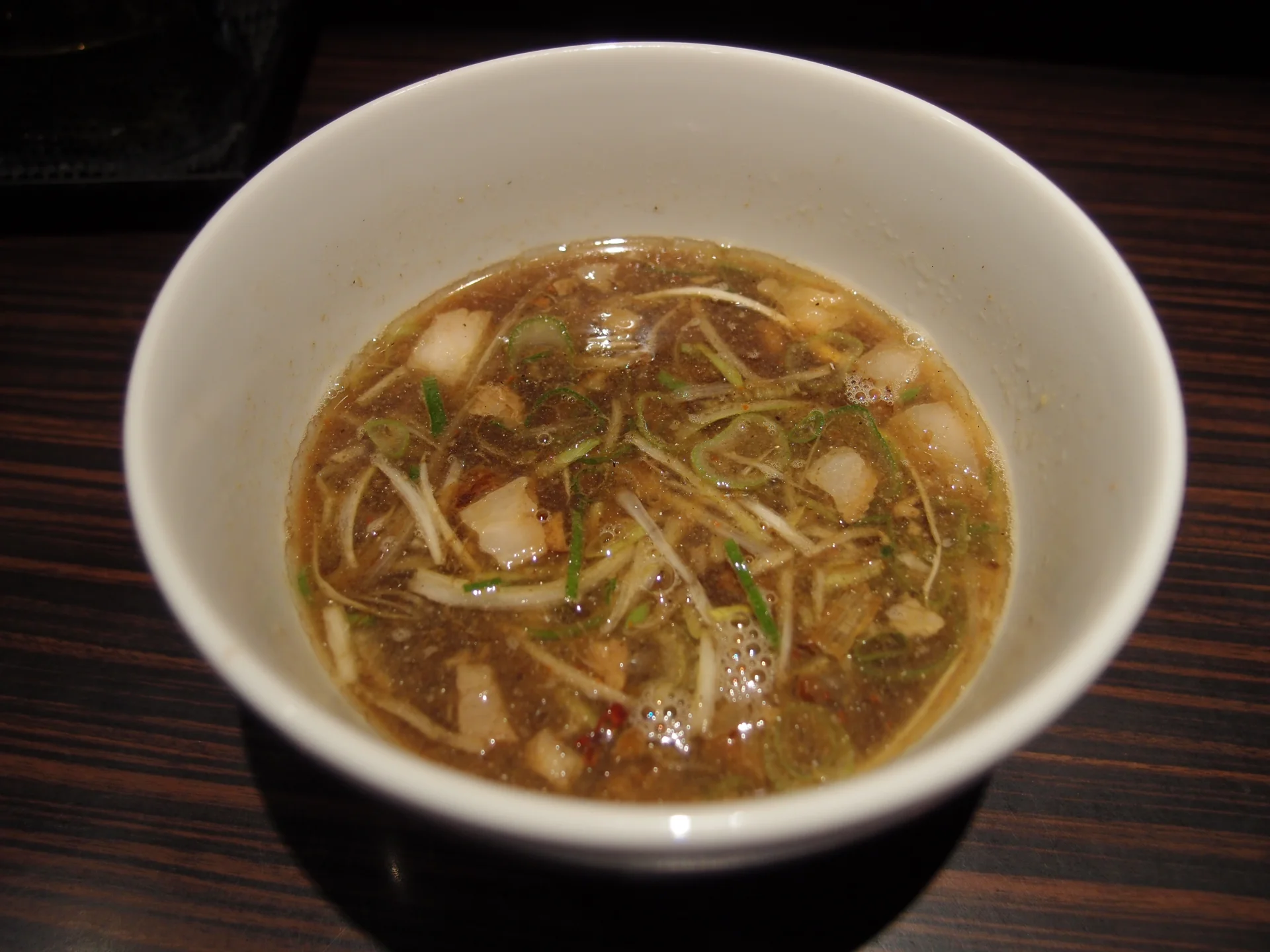 Two-bowl service of shoyu tsukemen: cold kansui noodles in one bowl and hot concentrated dipping broth in another