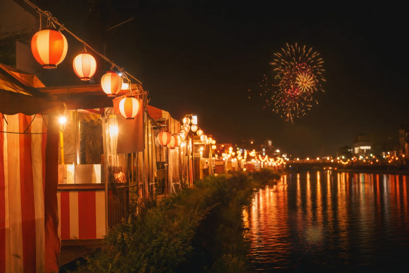Paper lanterns and fireworks over the river at a Tokyo summer festival