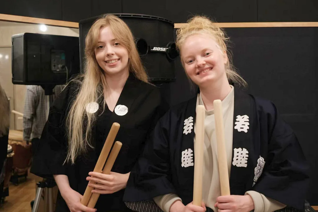 Travelers wearing happi coats during taiko workshop in Tokyo
