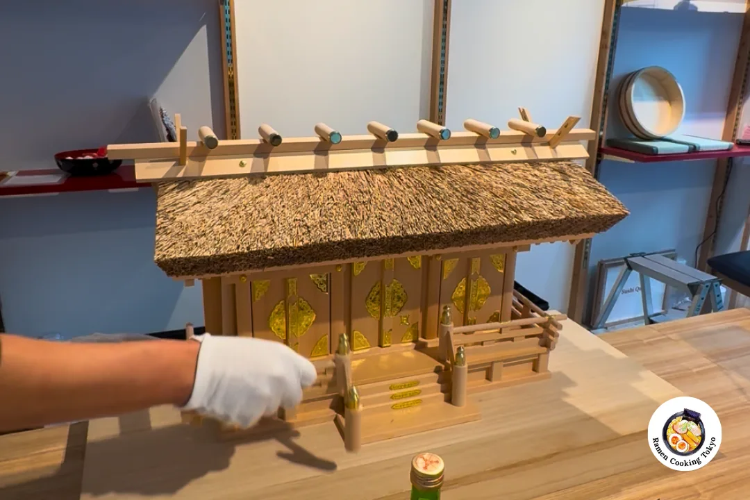 The miyadaiku master carefully installing the kamidana