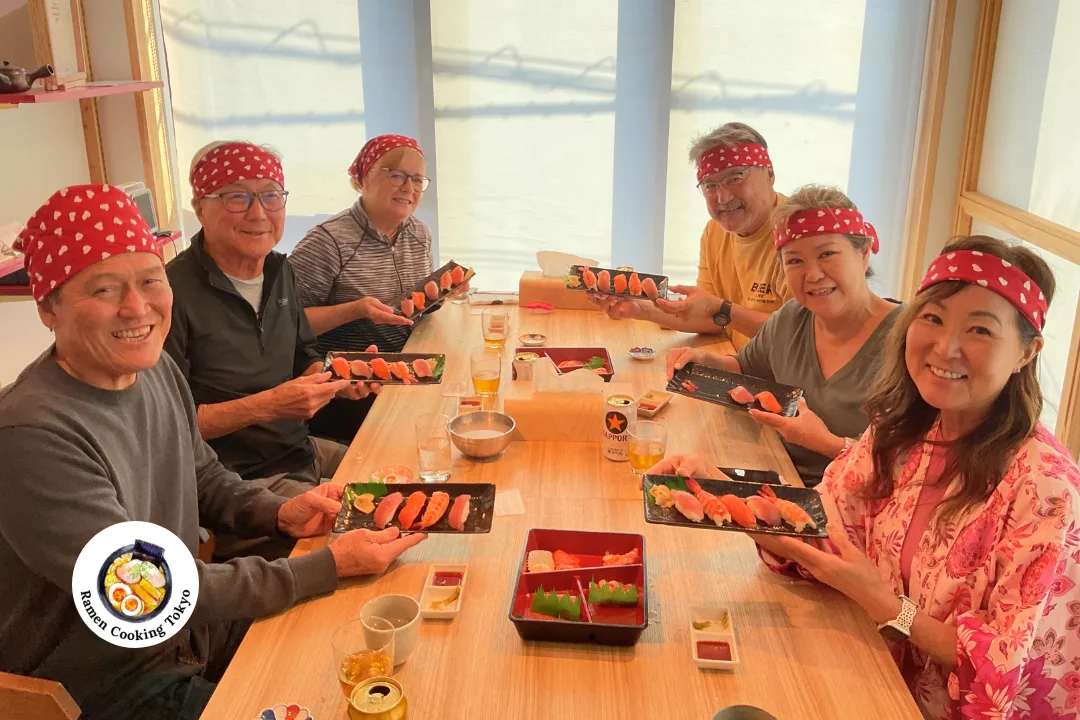 Guests sharing a sushi meal around a communal table in a Japanese-style room