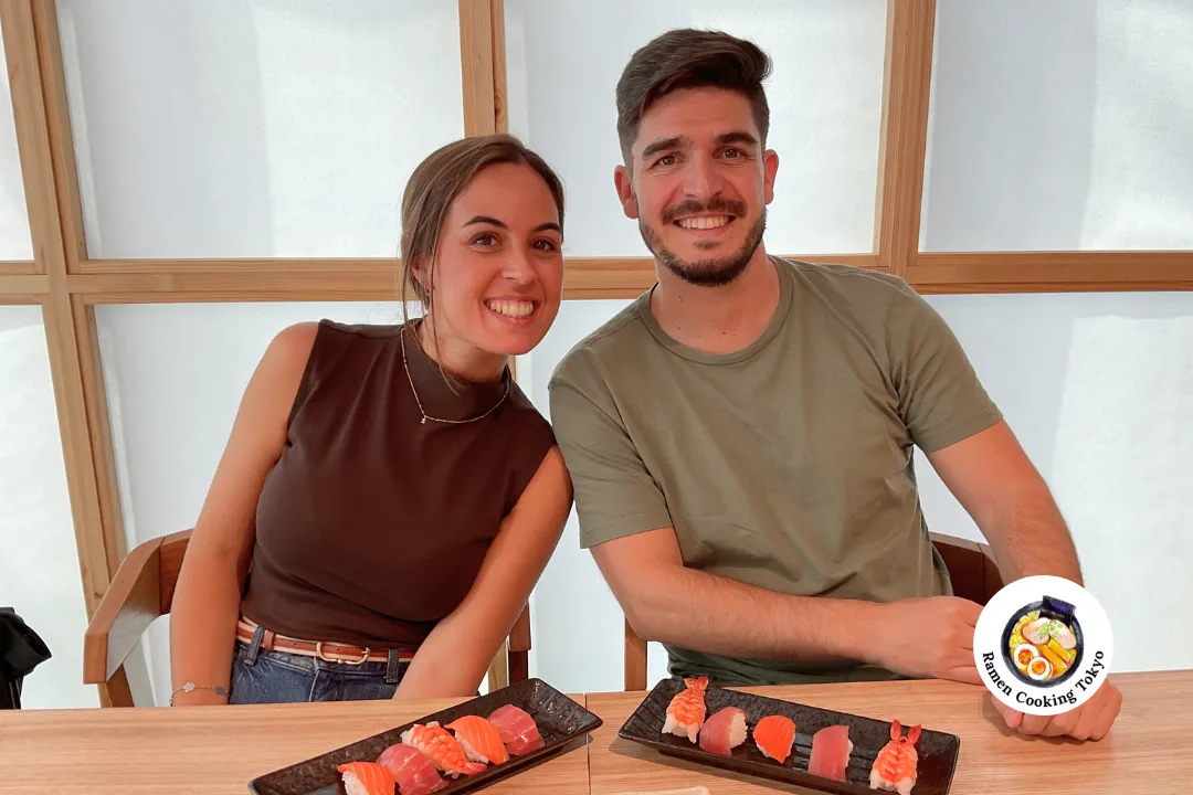 A couple with handmade nigiri sushi in a Japanese-style room at a Tokyo cooking class