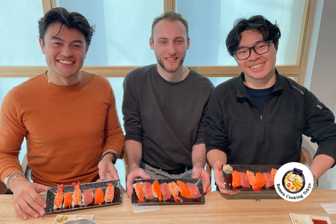 Three friends holding their finished sushi platters at a Tokyo class