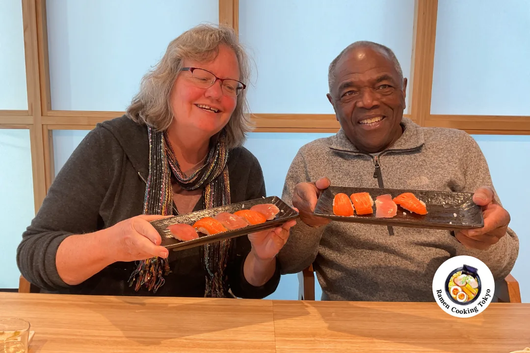 A mature couple presenting handmade sushi at a Tokyo class