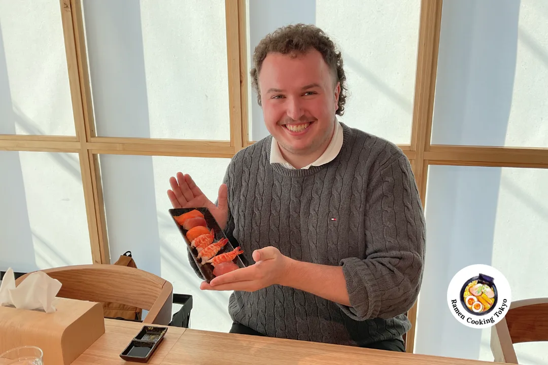 A solo guest holding a finished sushi platter at a Tokyo class
