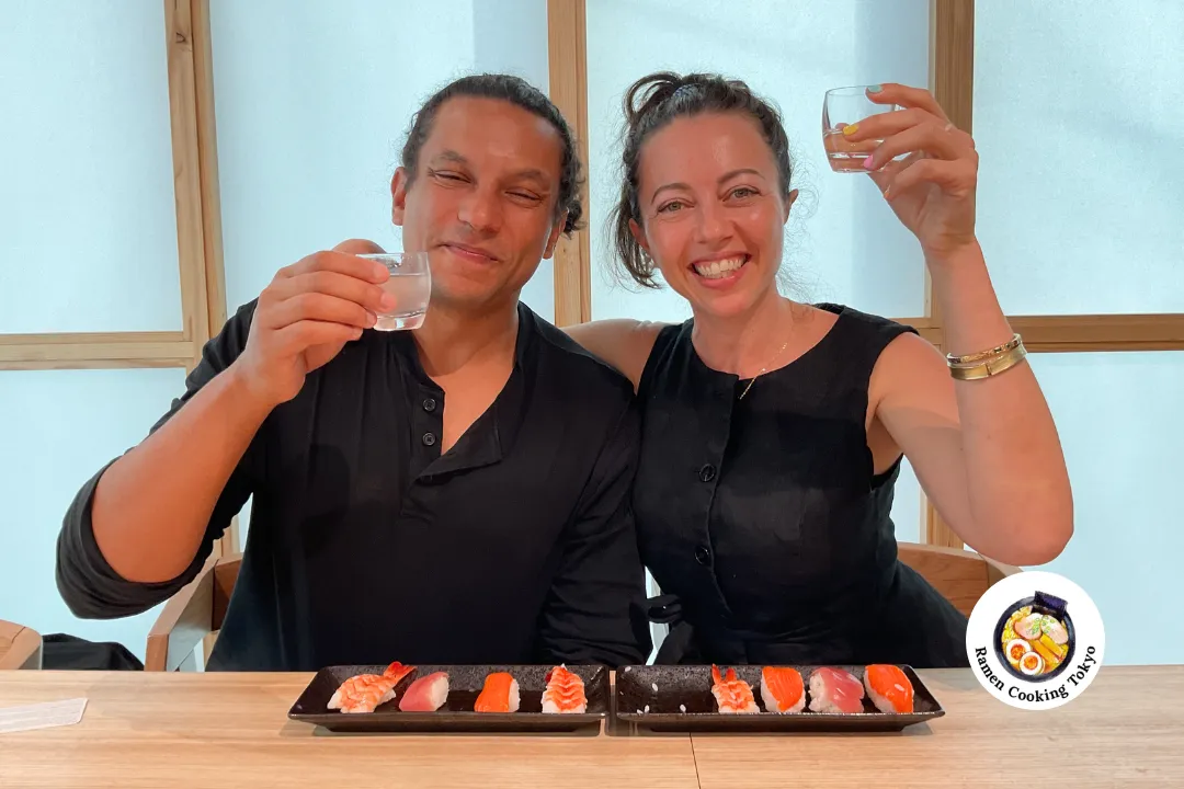 Ein Paar stößt mit Sake auf ihr selbstgemachtes Sushi an