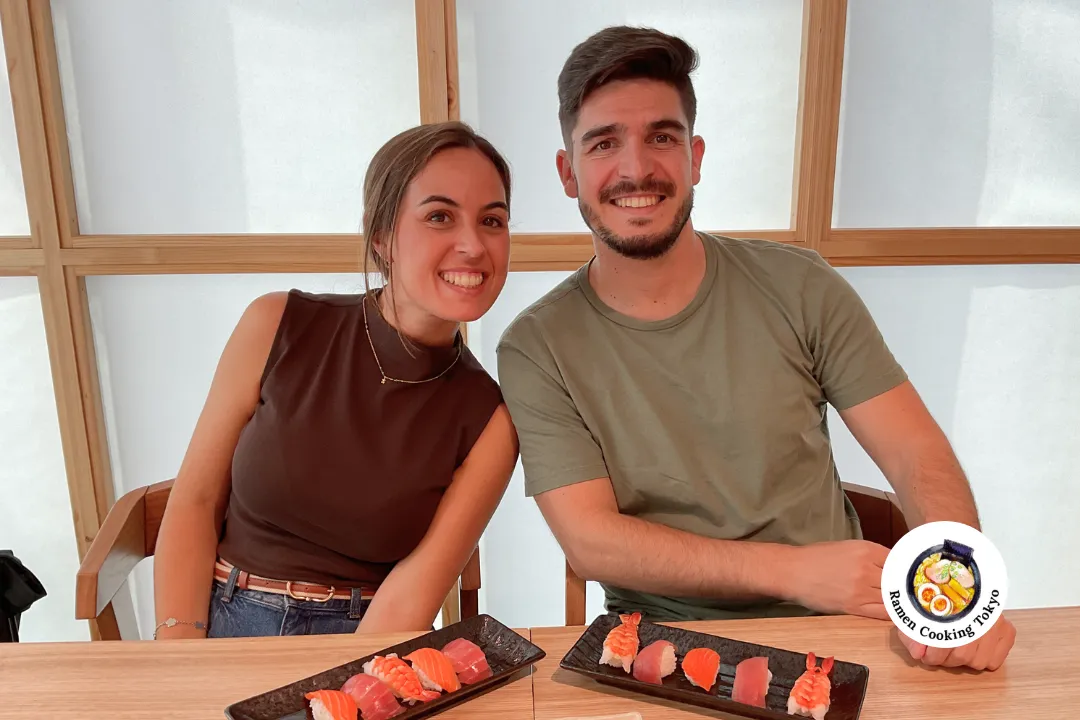 Ein Paar hält selbstgemachtes Sushi vor traditionellen Shoji-Paneelen