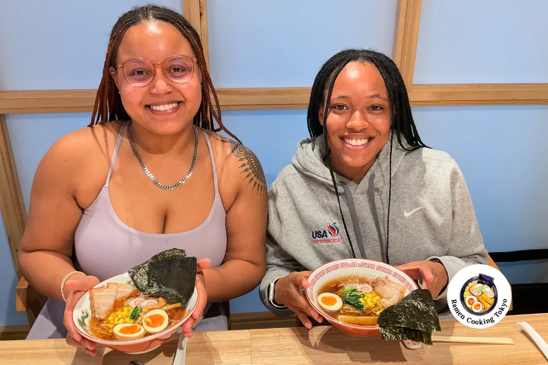 Zwei Freundinnen lächeln mit selbstgemachten Ramen-Schalen in unserer Kochklasse in Tsukishima