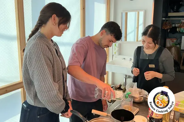 Pareja cocinando caldo de ramen con guía del instructor